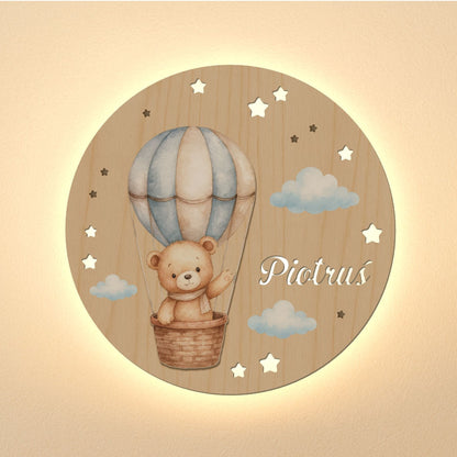 Wooden wall decor with a teddy bear in a hot air balloon and the name 'Piotrus' on a beige background.