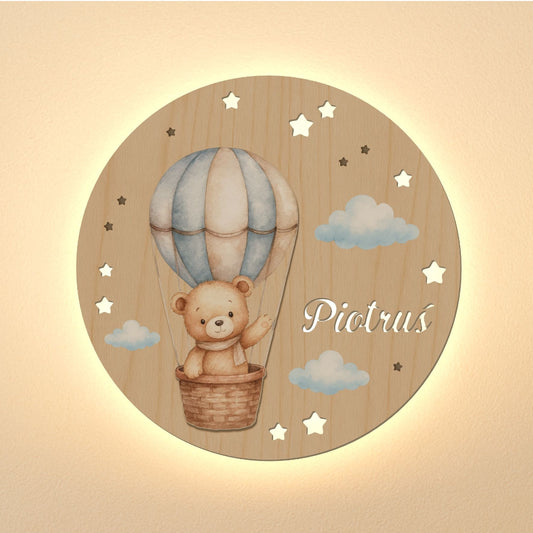 Wooden wall decor with a teddy bear in a hot air balloon and the name 'Piotrus' on a beige background.