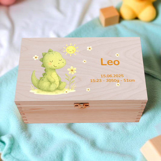 Wooden box with a dinosaur illustration and text, surrounded by toys on a blanket