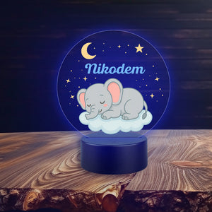 Elephant on Cloud Lamp
Lampka Słoń na Chmurce
Decorative night light with a sleeping elephant design and personalized name on a wooden surface.
