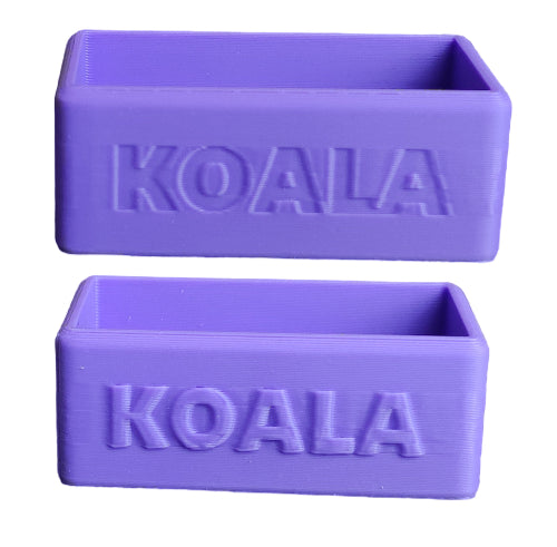 Two purple rectangular 3D-printed planters with the word 'KOALA' embossed on the front, shown against a plain white background.