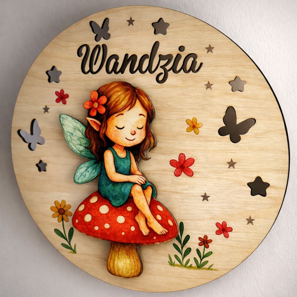 Wooden plaque with a fairy design and 'Wandzia' text on a wooden background
