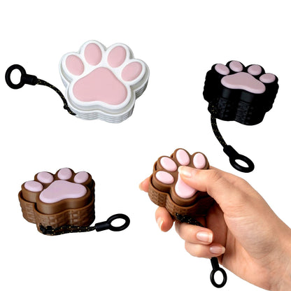 Paw-shaped keychain with a hand holding one of them on a white background