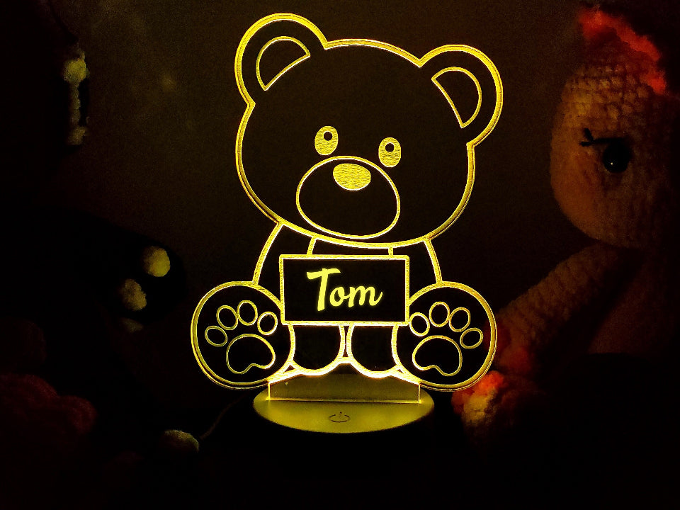 Teddy bear lamp with the name Laurence, offering multicolour LED lighting, USB or battery operation, and a control feature.