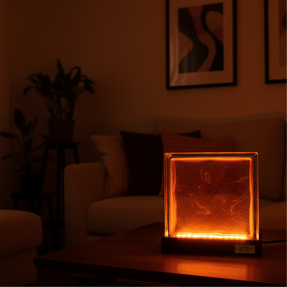 Glass block light on a table in a dimly lit room with a couch and plant in the background