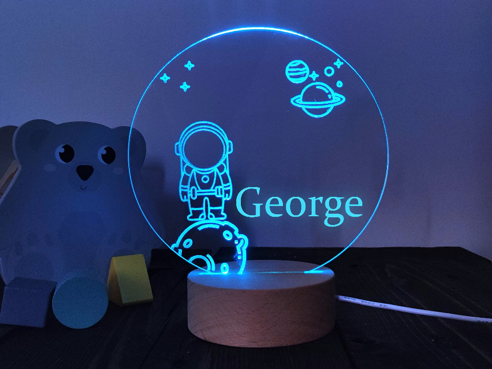 Multicolored astronaut 3D LED night light, USB or battery-operated, featuring a controller for adjustable brightness.