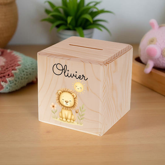 Wooden money box with lion design and 'Olivier' engraving on a wooden surface.